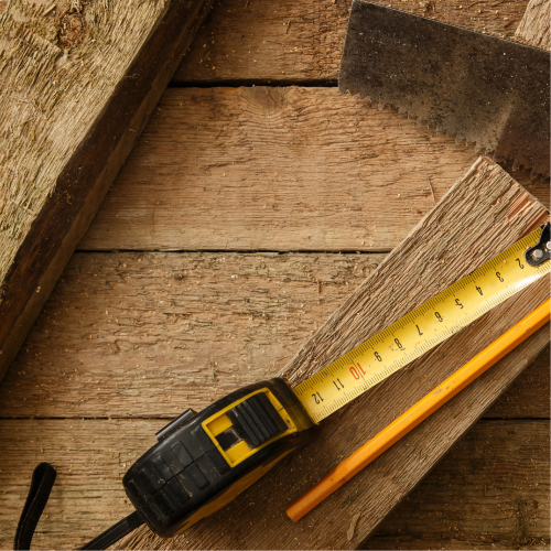 Tape measure and pencil on a wooden surface