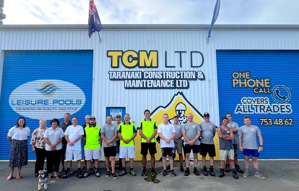 Group of people posing in front of Taranaki Construction & Maintenance Ltd building