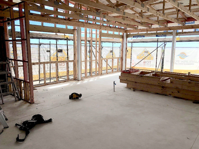 Underconstruction building with wooden frames and tools on a concrete floor