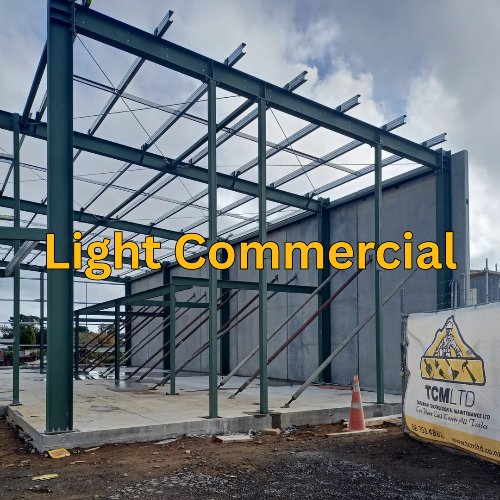 Light commercial building under construction with 'TCLM LTD' sign in the background.