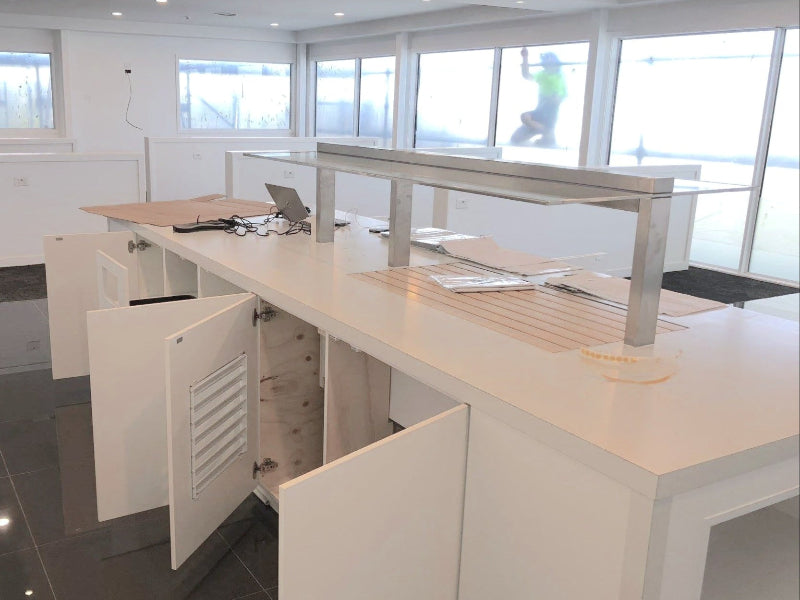Modern office interior with white desks and glass partitions.