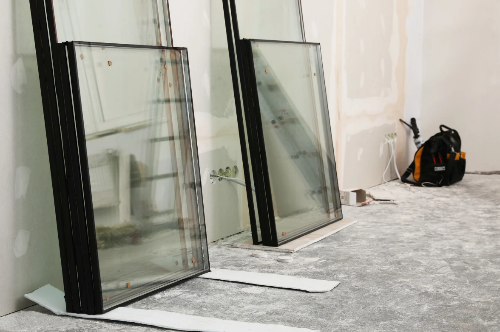 Glass panels on a floor with tools and equipment in the background